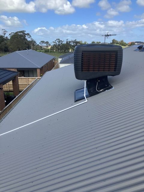 An evaporative cooler on a new home's roof