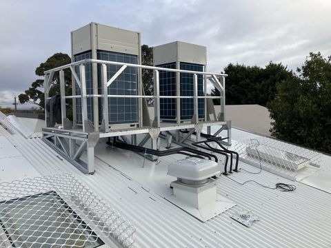 Two commercial condensing units on a rooftop platform