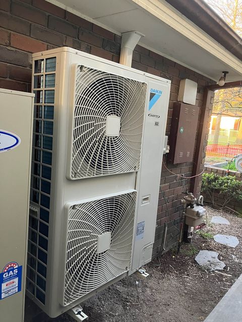 A ducted outdoor unit beside a gas ducted heater
