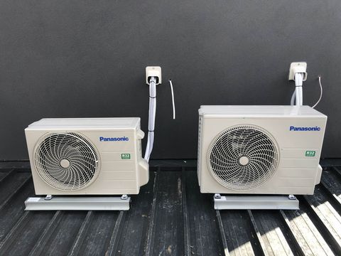 Two split system outdoor units on a roof deck