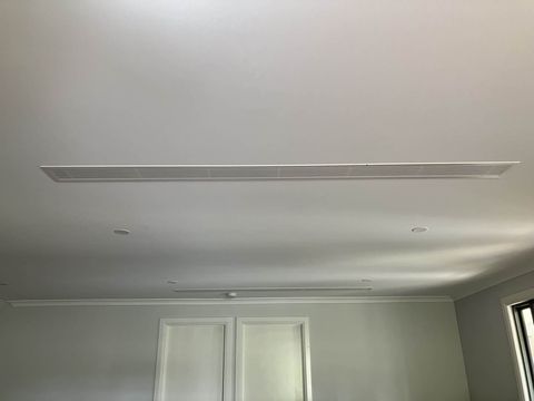 Two linear slot diffusers across a living room ceiling