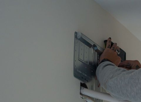 Fixing the wall plate for a split system, with the pipe hole below